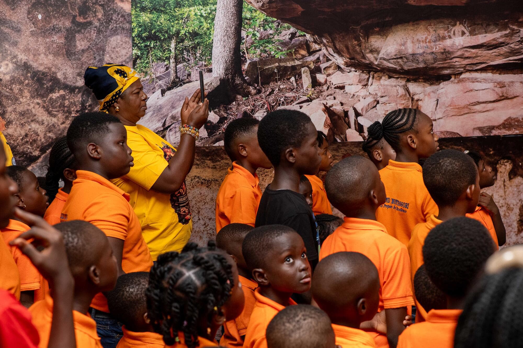 A guide pointing out details in a rock-art exhibit to a group of Graceland pupils