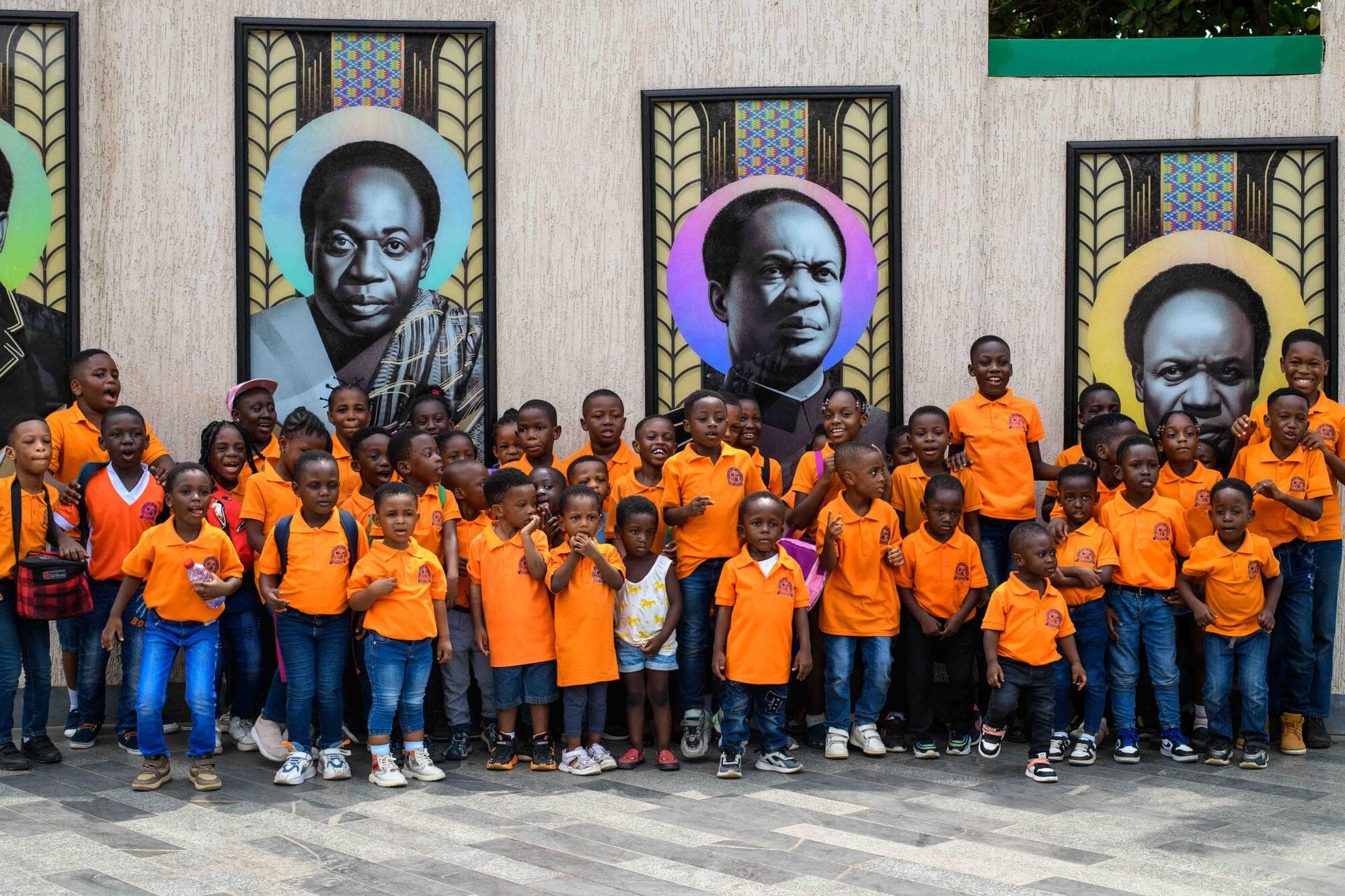 Graceland pupils and staff gathered beneath a wall of portraits of Ghana's founding figures