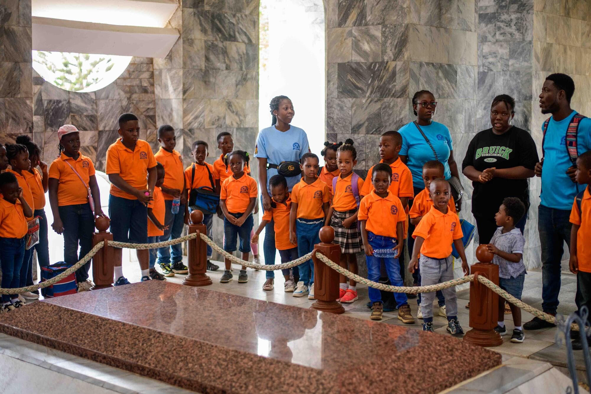 Pupils gathered around the mausoleum's tomb listening to a guide