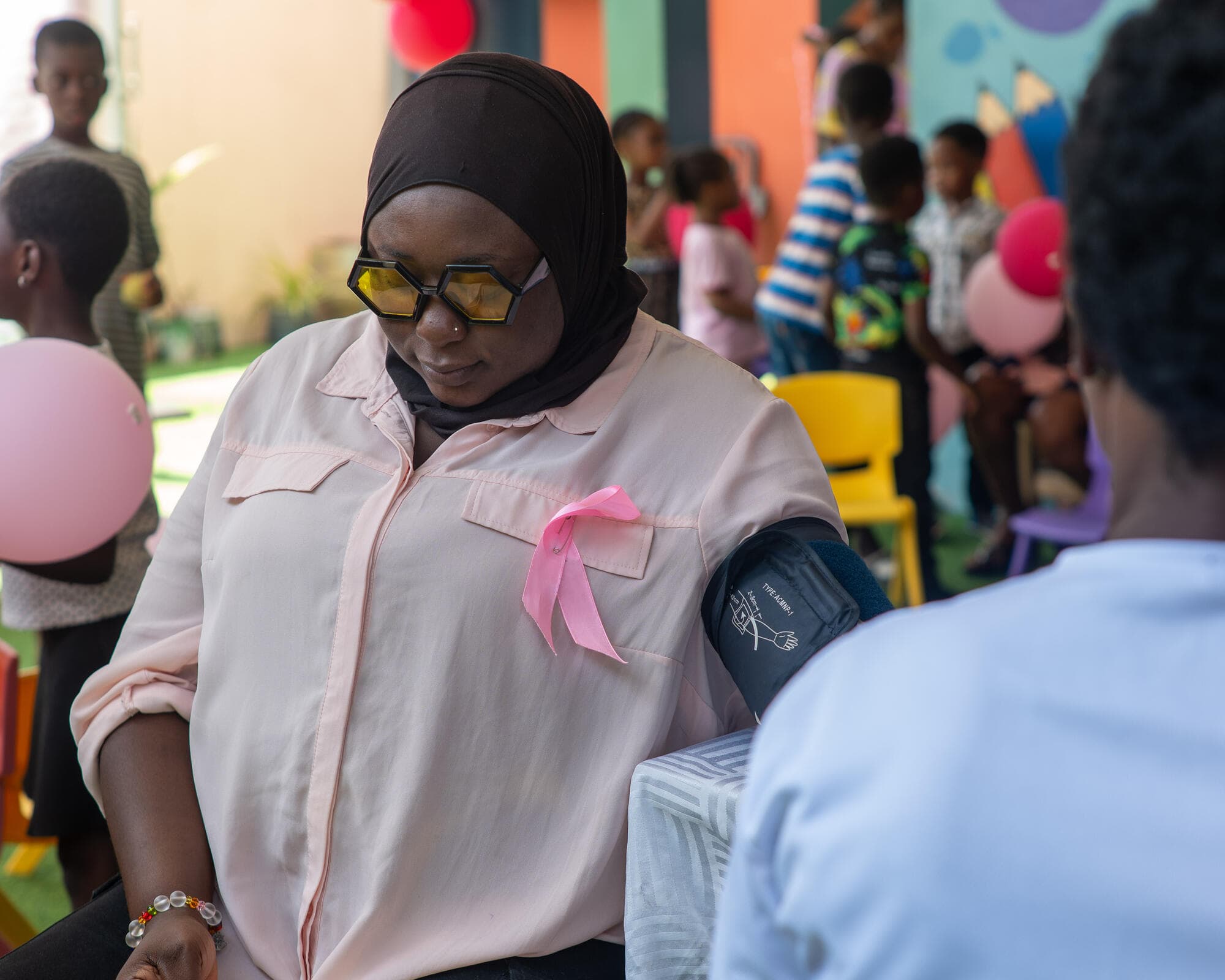 A woman having her blood pressure checked by a health volunteer