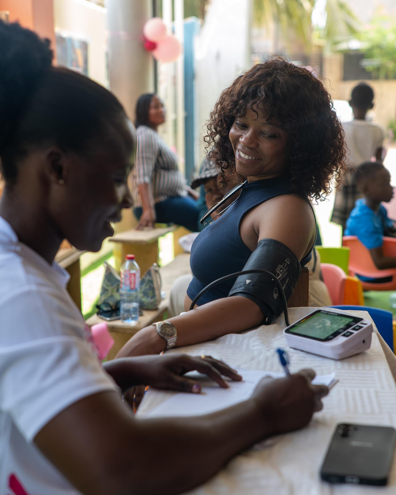 A health volunteer speaking with a community member at a consultation table