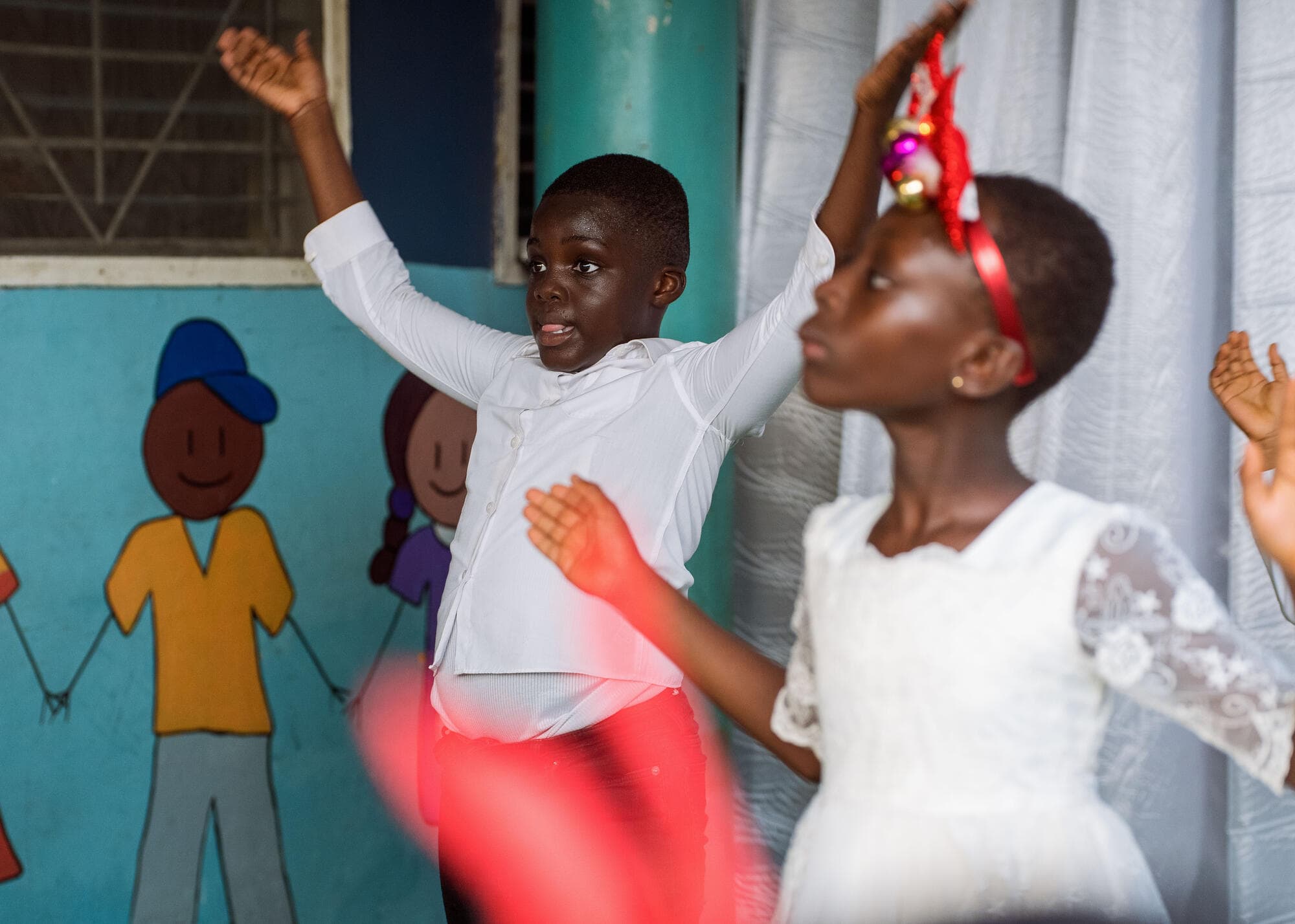 Pupils dancing energetically on stage during the Carols Day celebration