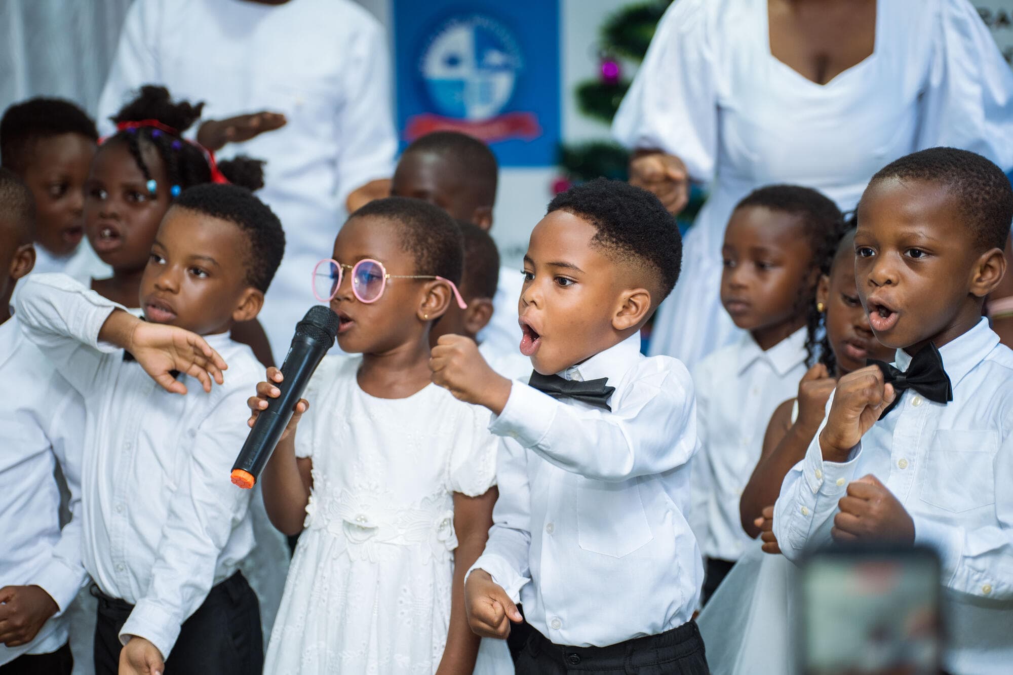 Graceland pupils singing energetically into a microphone on stage