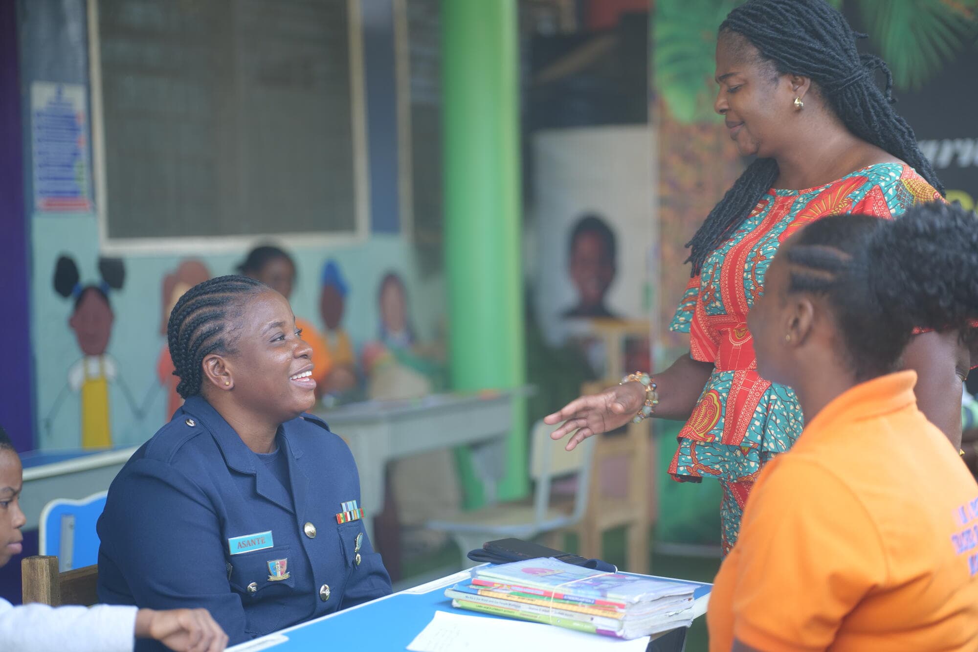 A parent in uniform being welcomed by staff for her consultation